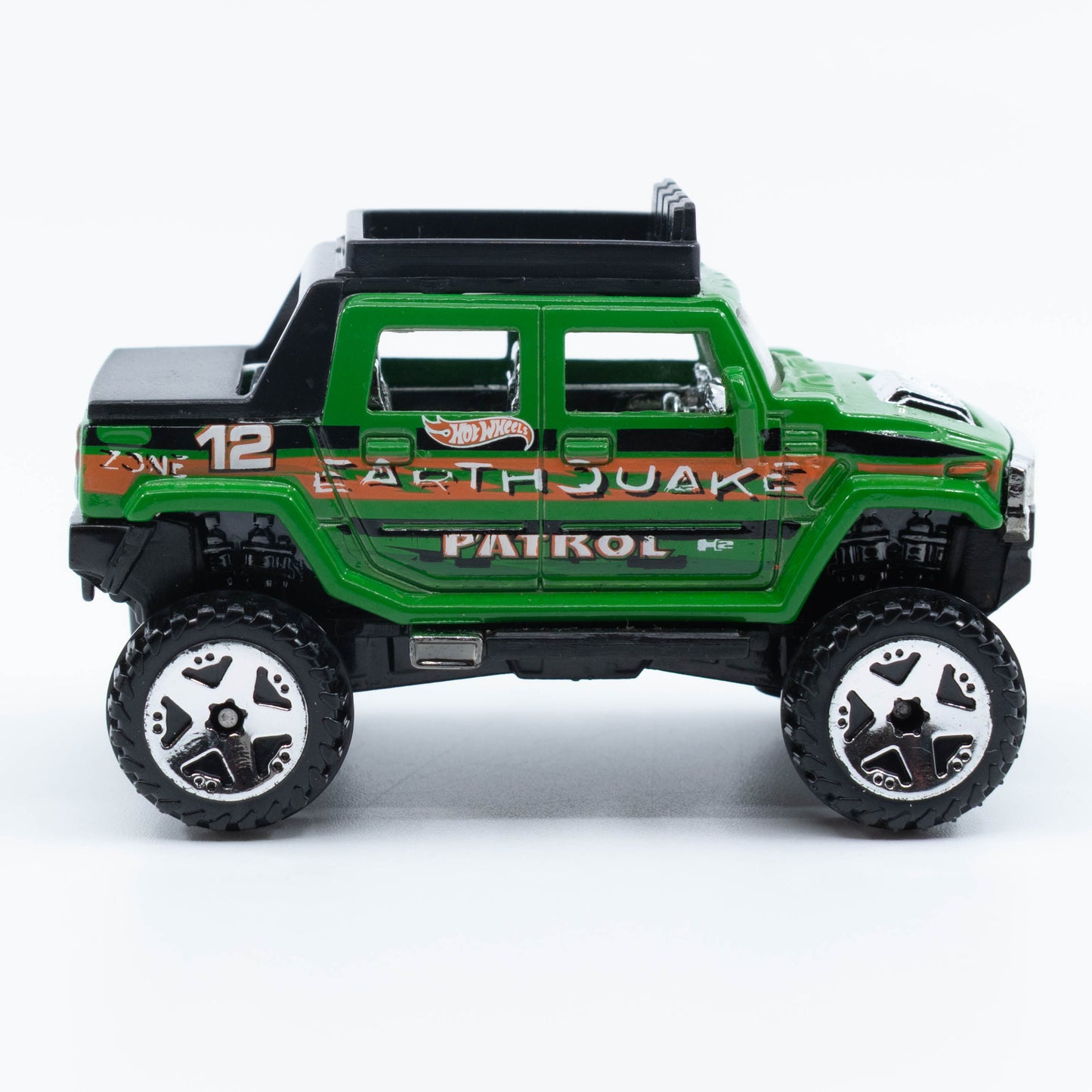 Hot Wheels Hummer H2 SUT diecast model in 1:64 scale with lifted suspension and off-road styling. Side