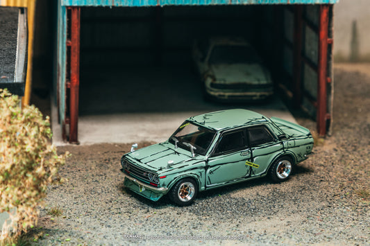 Tarmac Works 1973 Datsun 510 Bluebird Wagon SSS in green, a 1:64 Hobby64 diecast model in an acrylic display case.