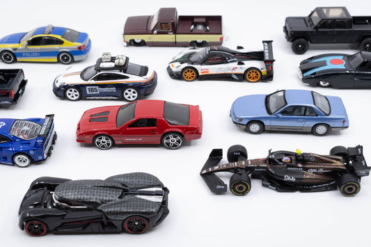 A lineup of 1:64 scale diecast cars from various brands, featuring JDM, police, trucks, Formula One, and movie-themed models.