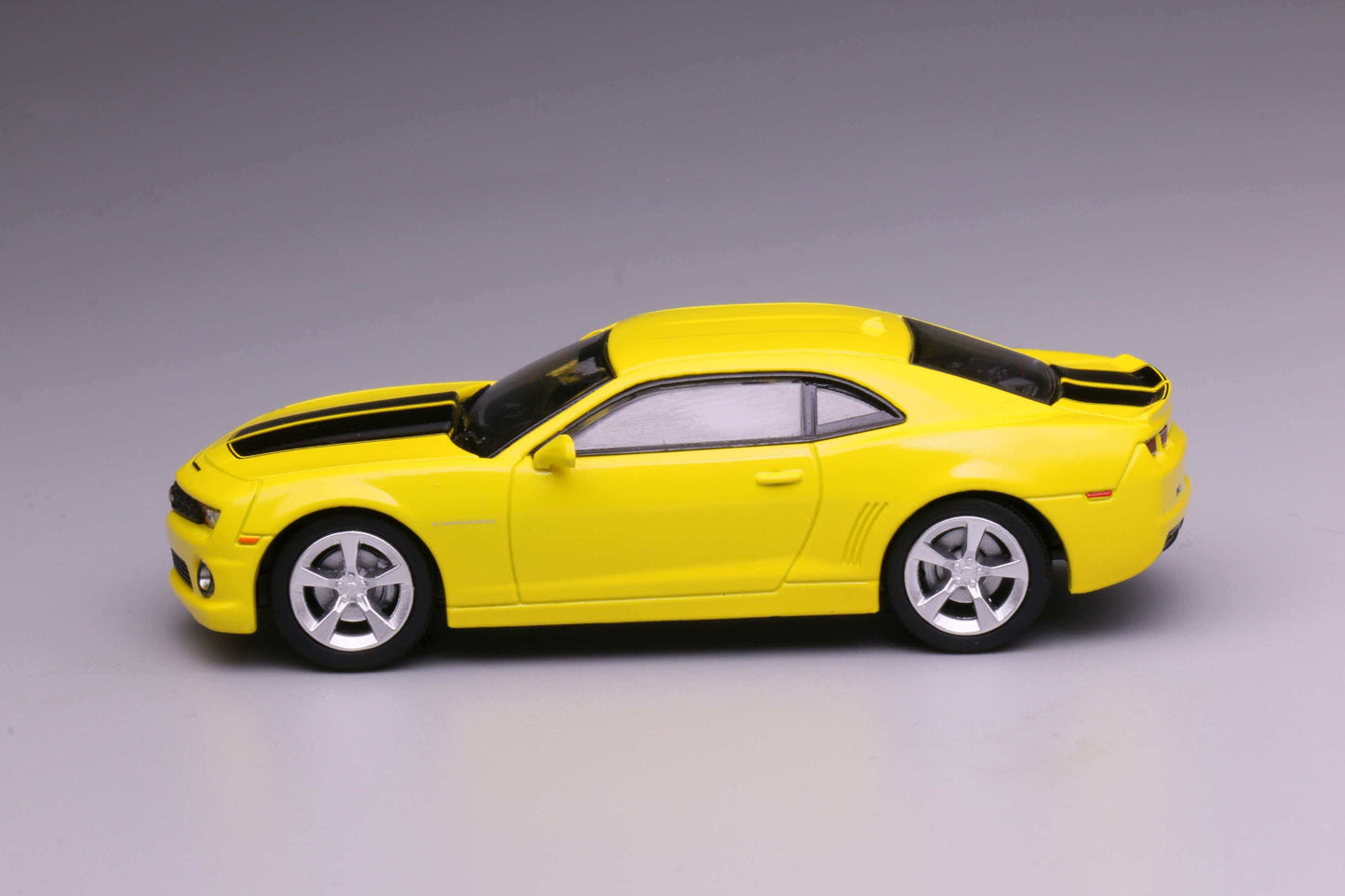 596 Models 2009 Chevrolet Camaro in yellow with black racing stripes. Side