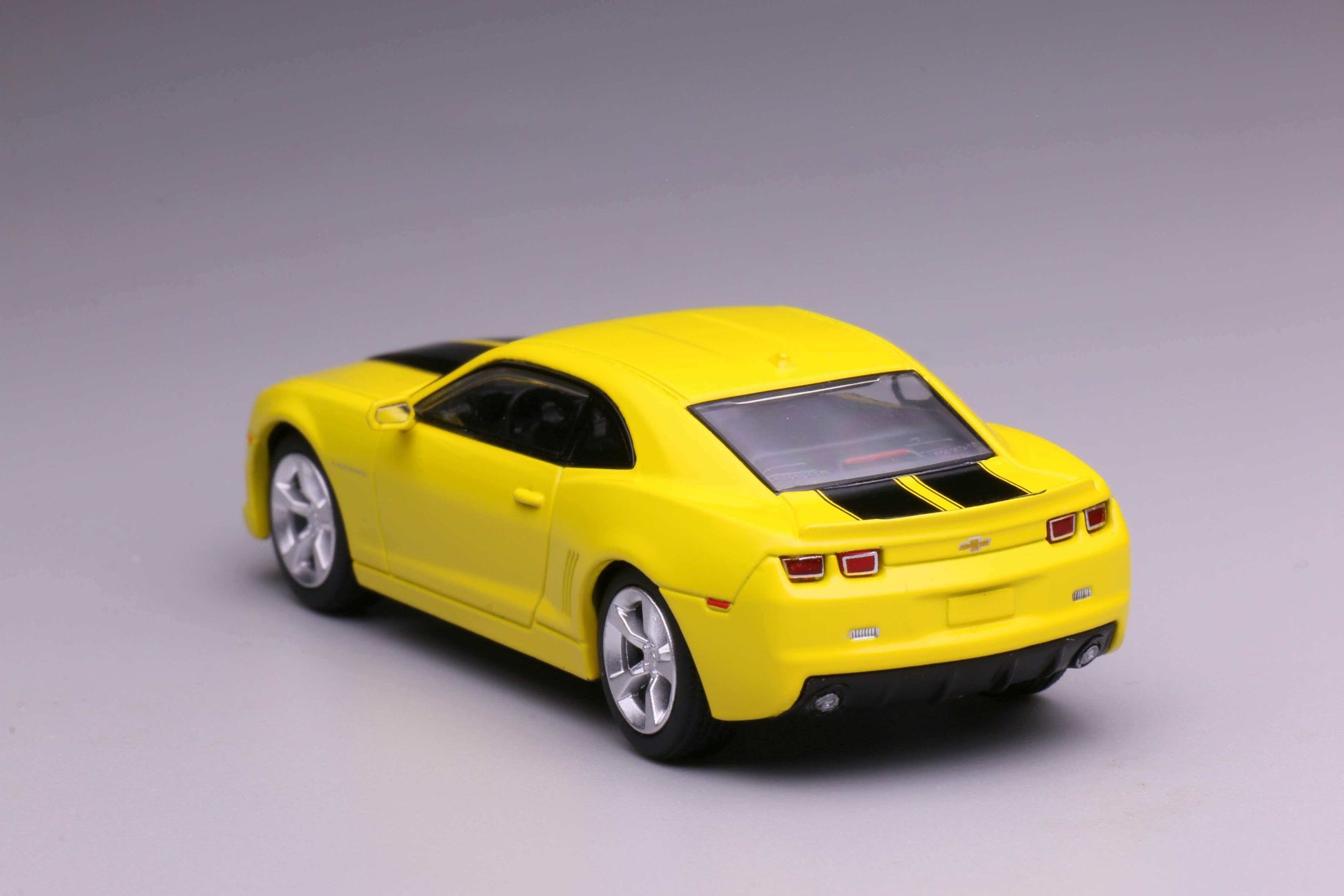 596 Models 2009 Chevrolet Camaro in yellow with black racing stripes. Back