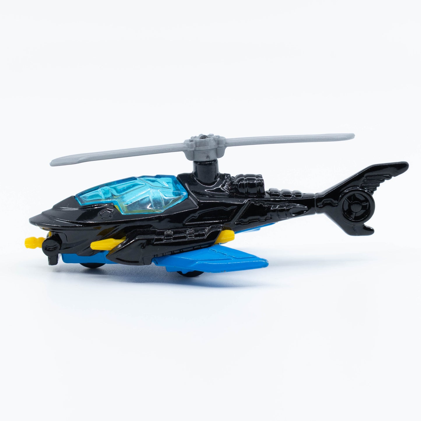 Hot Wheels Batcopter in 1:64 scale with black bat-wing design and spinning rotor blades. Side