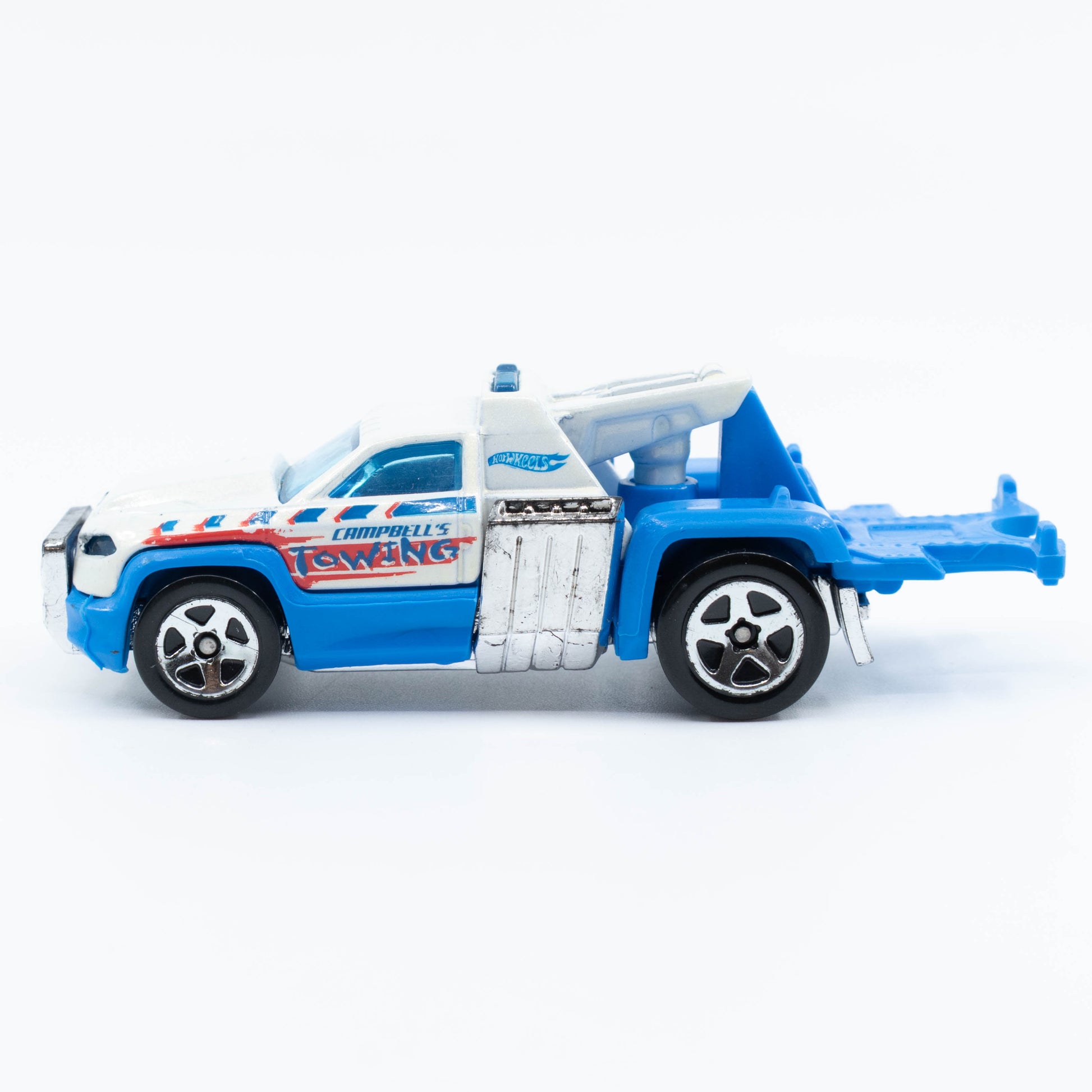 Hot Wheels Repo Duty tow truck with hook and utility bed in 1:64 scale. Side