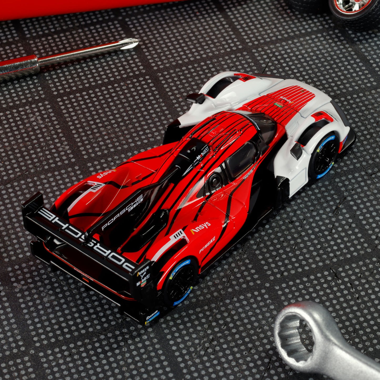 Hot Wheels Elite 64 Porsche 963 in Penske Team livery, featuring red, white, and black racing colors, detailed aero bodywork, and Real Riders wheels.