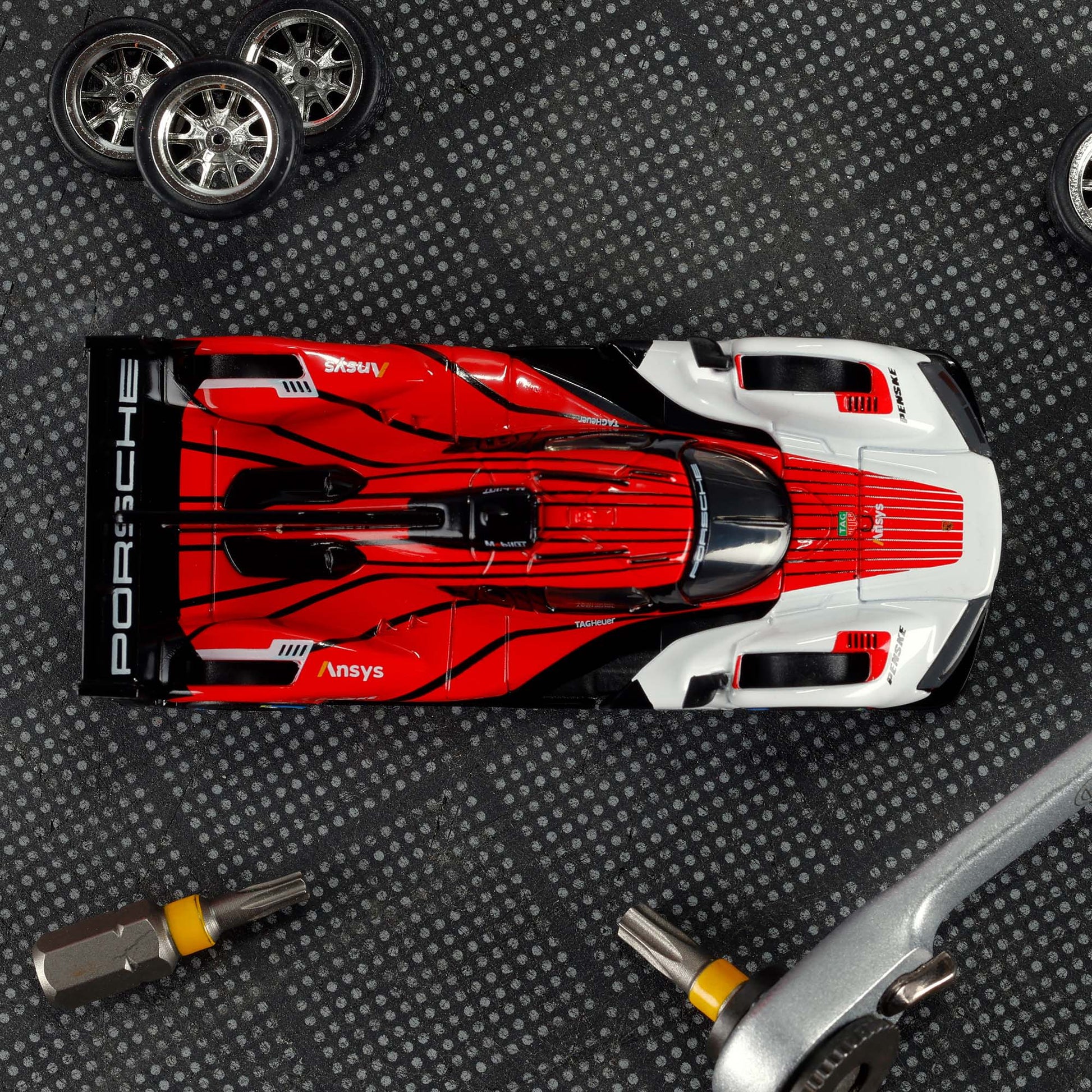 Hot Wheels Elite 64 Porsche 963 in Penske Team livery, featuring red, white, and black racing colors, detailed aero bodywork, and Real Riders wheels.