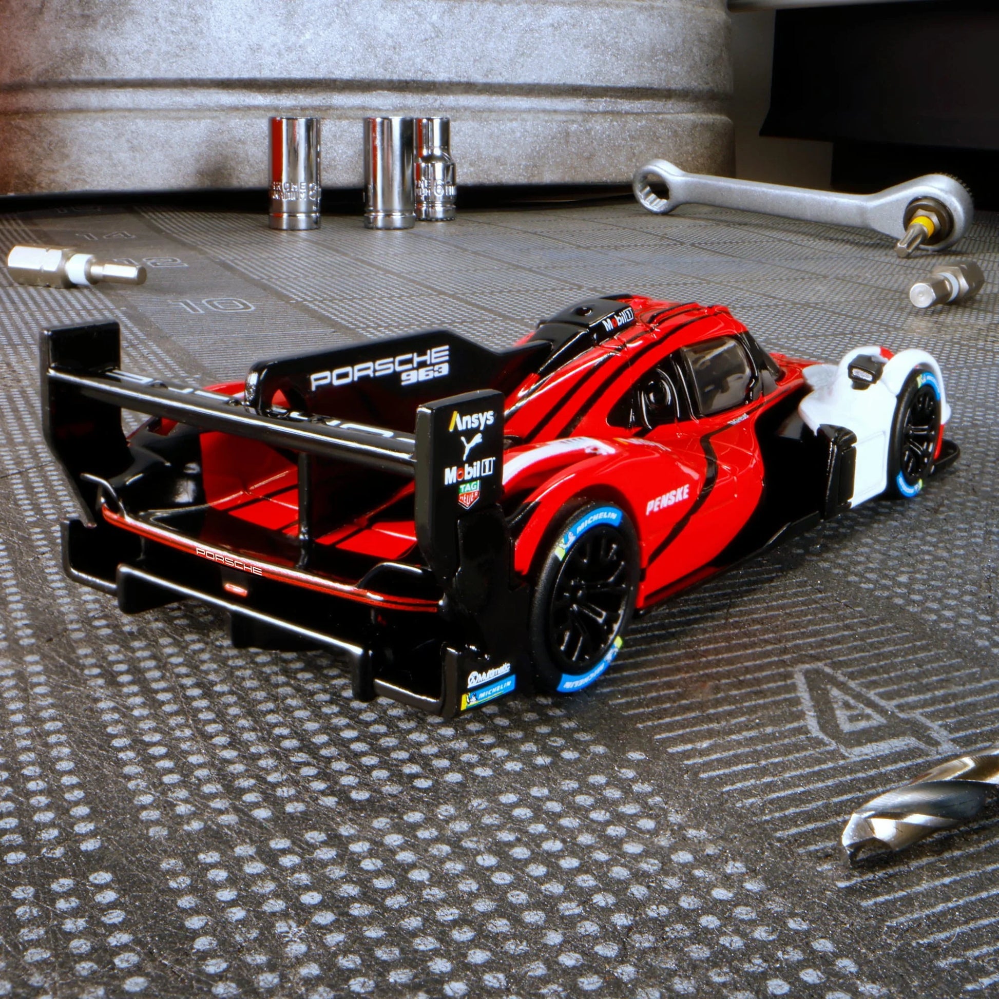 Hot Wheels Elite 64 Porsche 963 in Penske Team livery, featuring red, white, and black racing colors, detailed aero bodywork, and Real Riders wheels.