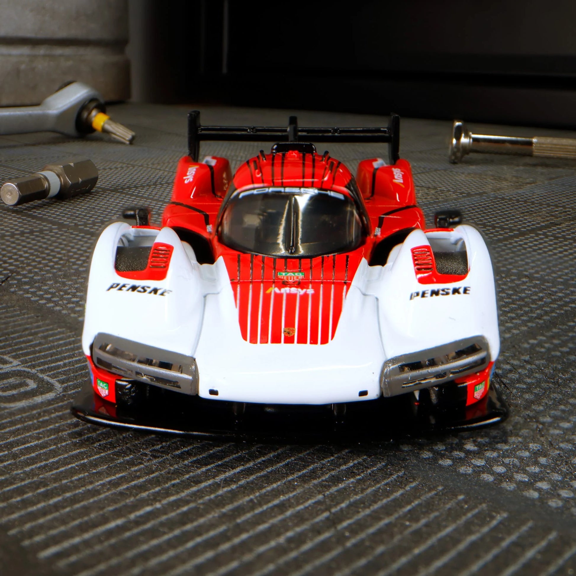 Hot Wheels Elite 64 Porsche 963 in Penske Team livery, featuring red, white, and black racing colors, detailed aero bodywork, and Real Riders wheels.