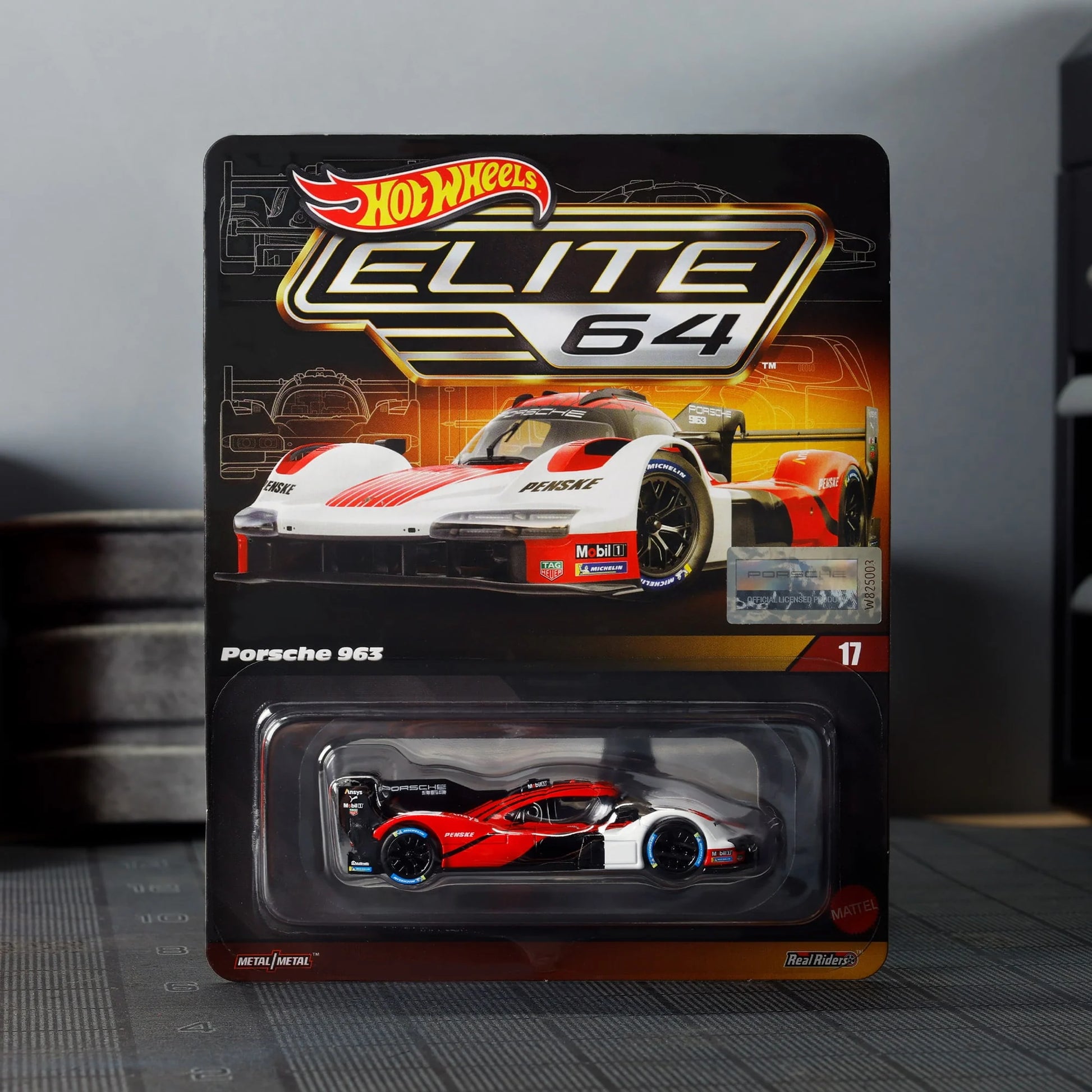 Hot Wheels Elite 64 Porsche 963 in Penske Team livery, featuring red, white, and black racing colors, detailed aero bodywork, and Real Riders wheels.