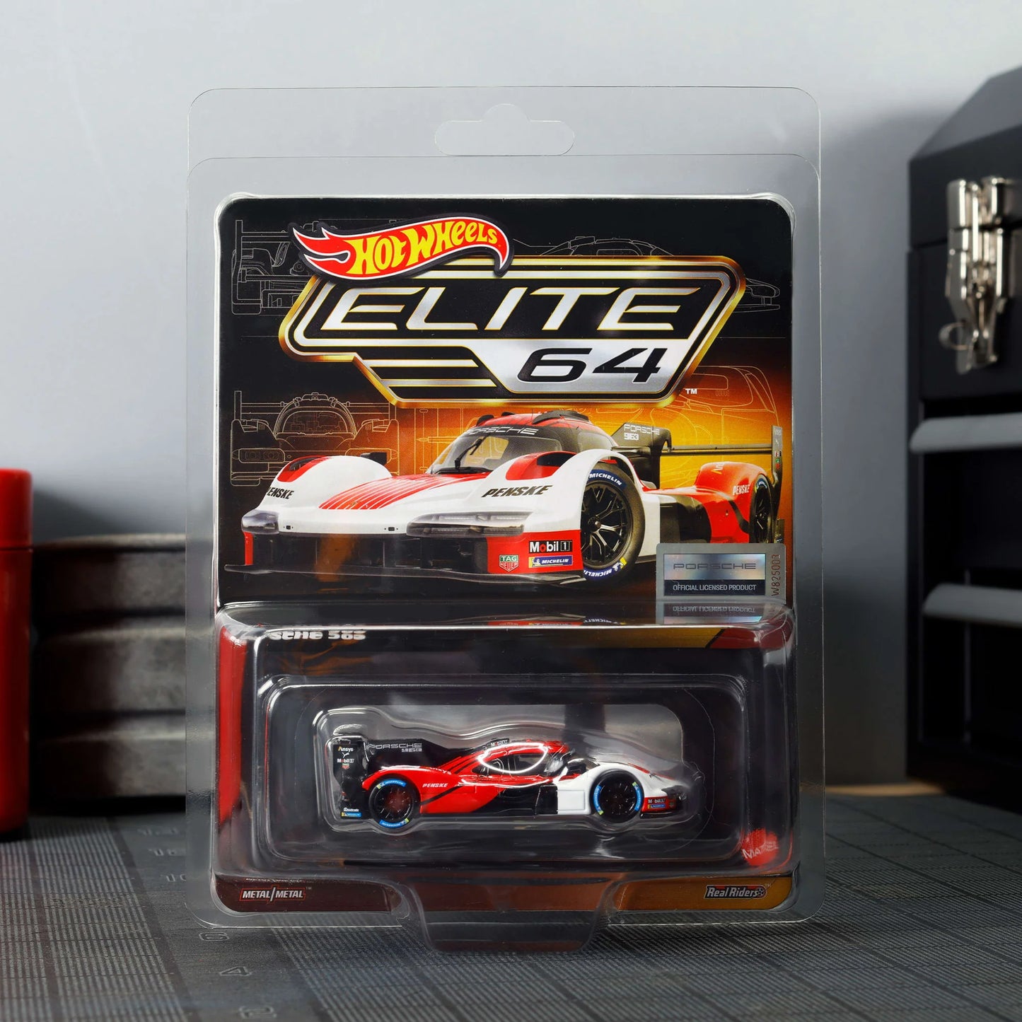 Hot Wheels Elite 64 Porsche 963 in Penske Team livery, featuring red, white, and black racing colors, detailed aero bodywork, and Real Riders wheels.