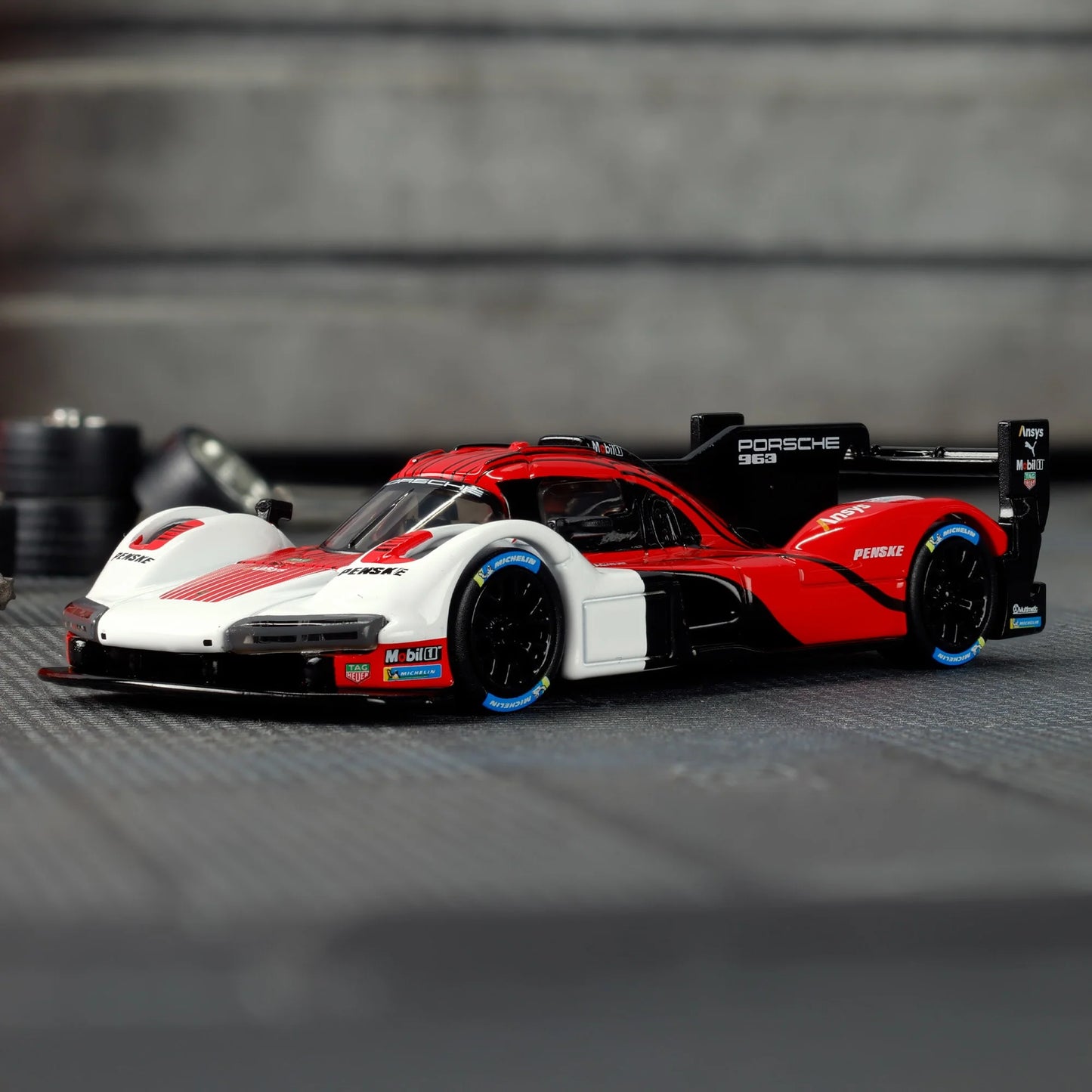 Hot Wheels Elite 64 Porsche 963 in Penske Team livery, featuring red, white, and black racing colors, detailed aero bodywork, and Real Riders wheels.