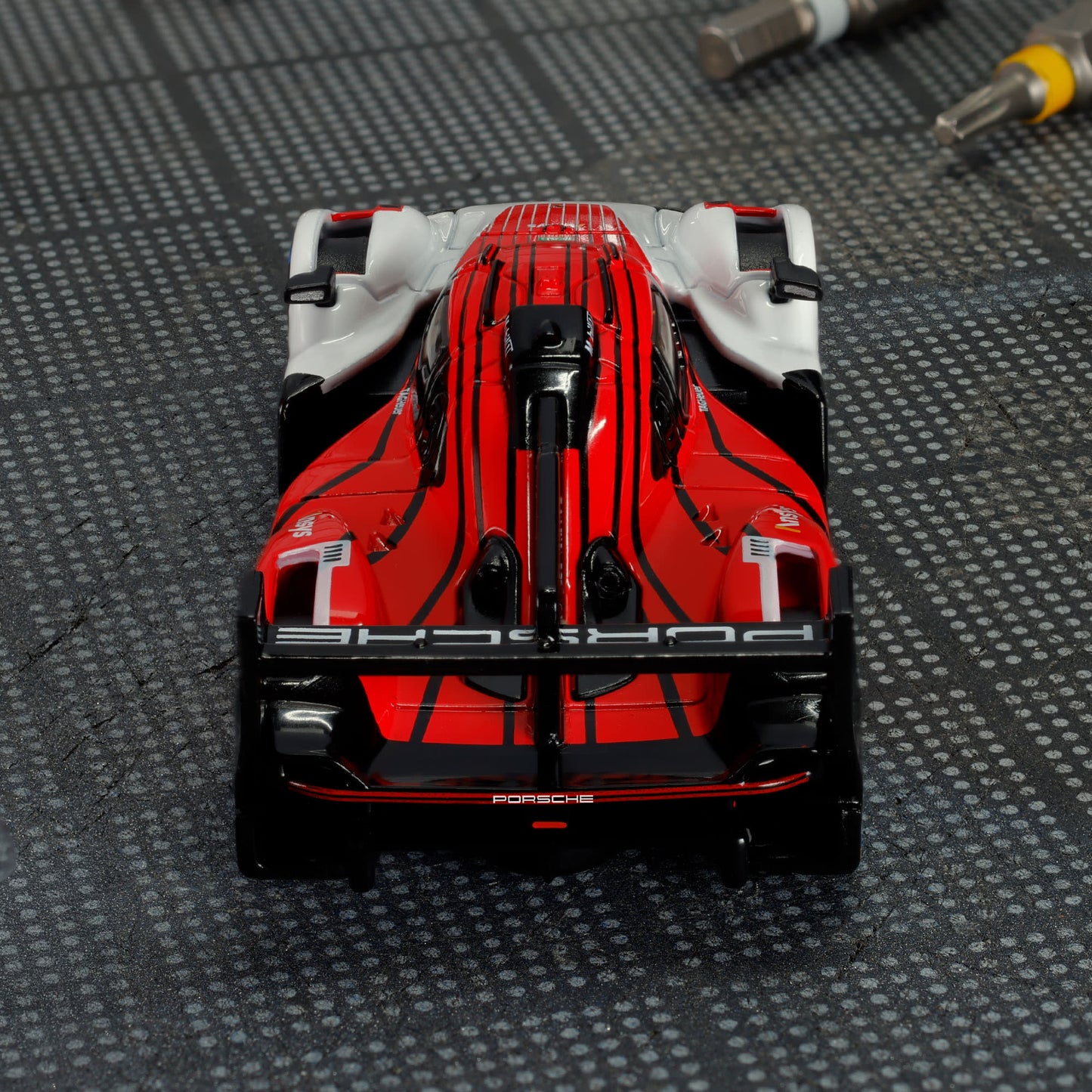 Hot Wheels Elite 64 Porsche 963 in Penske Team livery, featuring red, white, and black racing colors, detailed aero bodywork, and Real Riders wheels.