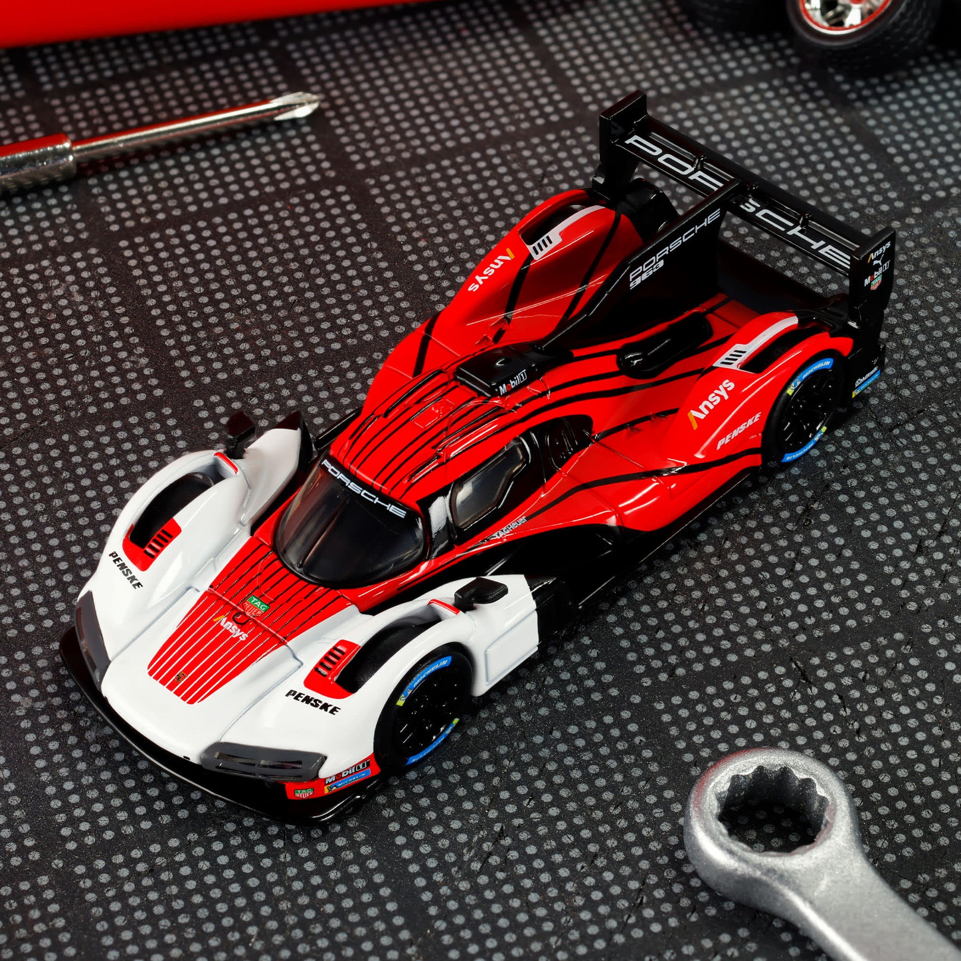 Hot Wheels Elite 64 Porsche 963 in Penske Team livery, featuring red, white, and black racing colors, detailed aero bodywork, and Real Riders wheels.