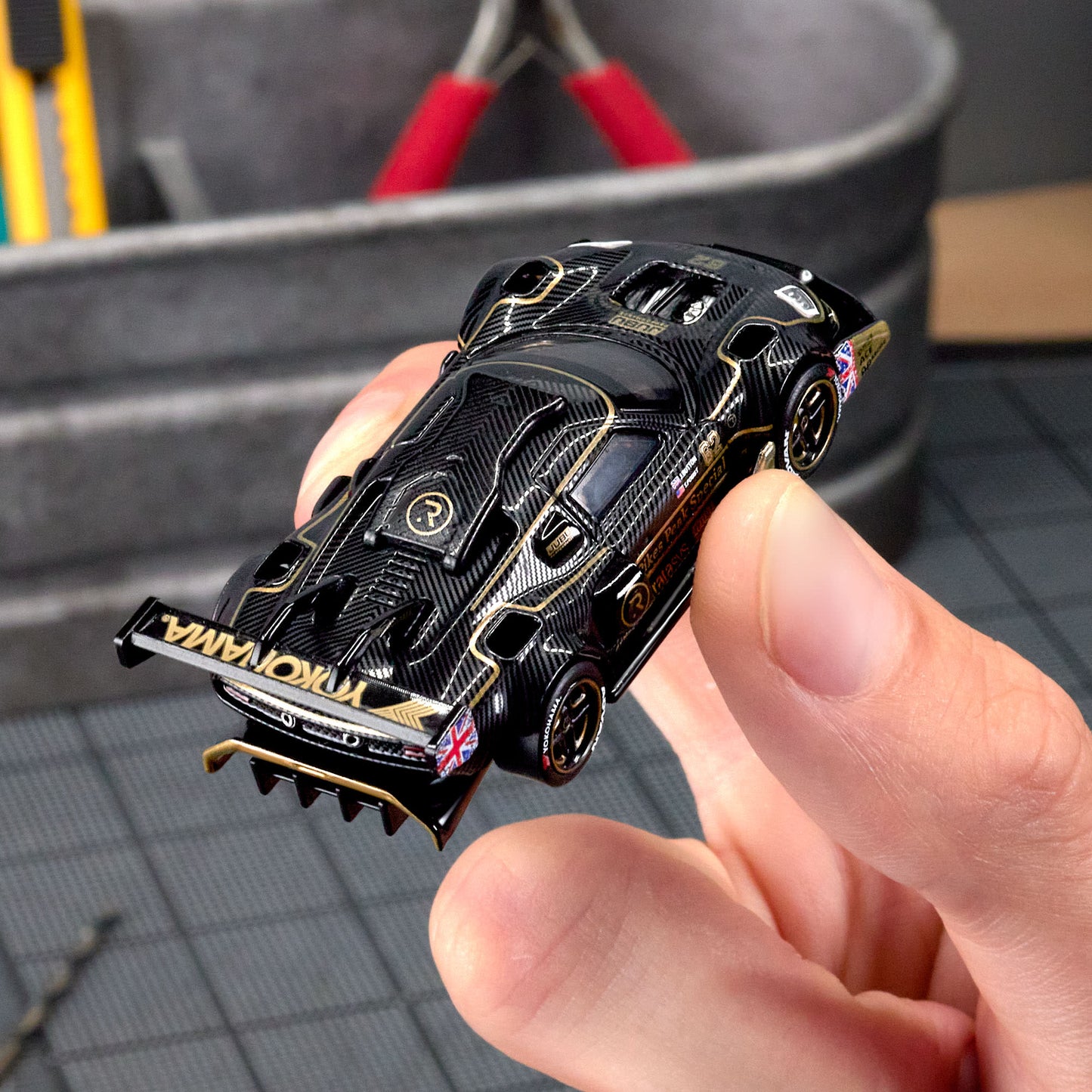 Hot Wheels Elite 64 Radford Type 62-2 Pikes Peak in black and gold JPS livery, featuring aerodynamic bodywork, gold Real Riders wheels, and fine race detailing.