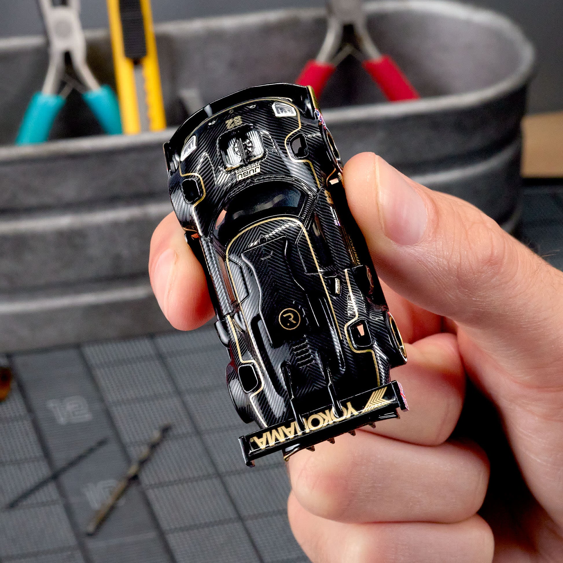 Hot Wheels Elite 64 Radford Type 62-2 Pikes Peak in black and gold JPS livery, featuring aerodynamic bodywork, gold Real Riders wheels, and fine race detailing.