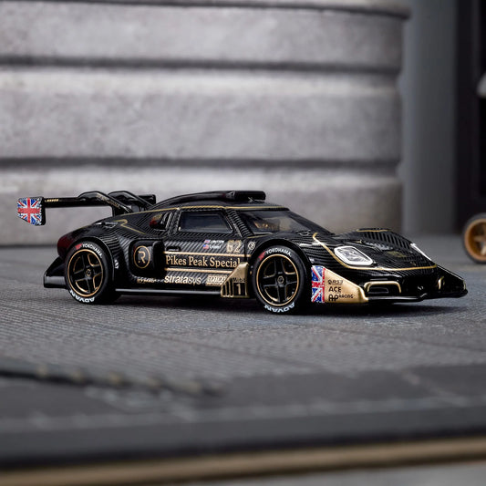 Hot Wheels Elite 64 Radford Type 62-2 Pikes Peak in black and gold JPS livery, featuring aerodynamic bodywork, gold Real Riders wheels, and fine race detailing.