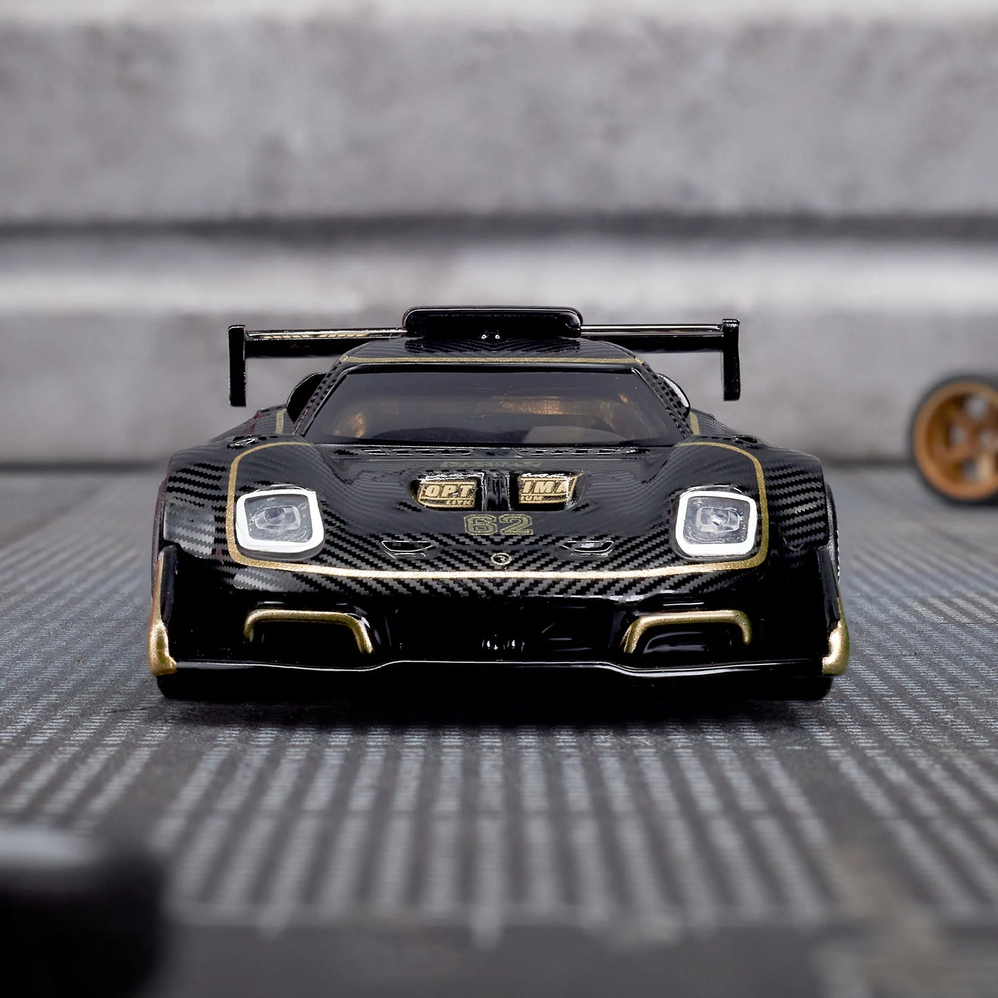Hot Wheels Elite 64 Radford Type 62-2 Pikes Peak in black and gold JPS livery, featuring aerodynamic bodywork, gold Real Riders wheels, and fine race detailing.