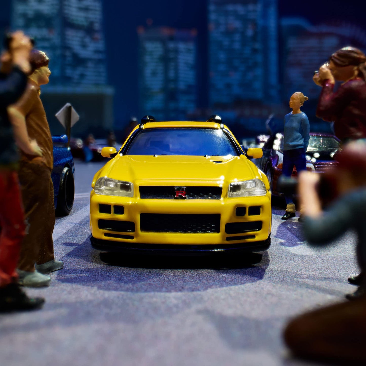 Hot Wheels Elite 64 Mod Shop Nissan Stagea in gloss yellow with interchangeable GT-R front end, opening hood, RB26 engine, and accessory kit.