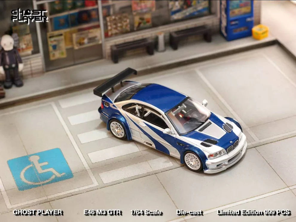 Street Weapon BMW M3 GTR diecast model inspired by Need for Speed: Most Wanted, featuring blue and silver livery, wide body kit, and rear wing in 1:64 scale.