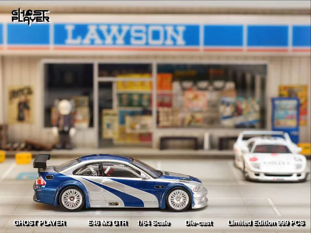 Street Weapon BMW M3 GTR diecast model inspired by Need for Speed: Most Wanted, featuring blue and silver livery, wide body kit, and rear wing in 1:64 scale.