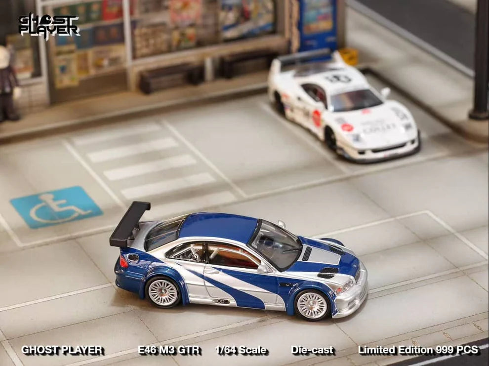 Street Weapon BMW M3 GTR diecast model inspired by Need for Speed: Most Wanted, featuring blue and silver livery, wide body kit, and rear wing in 1:64 scale.