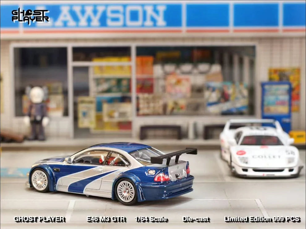 Street Weapon BMW M3 GTR diecast model inspired by Need for Speed: Most Wanted, featuring blue and silver livery, wide body kit, and rear wing in 1:64 scale.
