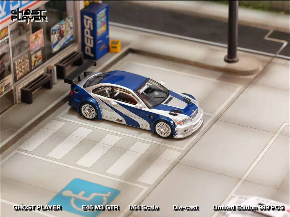Street Weapon BMW M3 GTR diecast model inspired by Need for Speed: Most Wanted, featuring blue and silver livery, wide body kit, and rear wing in 1:64 scale.