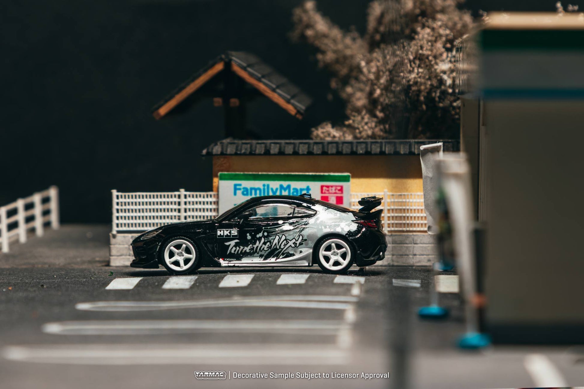 Tarmac Works 1:64 Toyota GR86 HKS black Tune the Next livery white wheels diecast model. Side